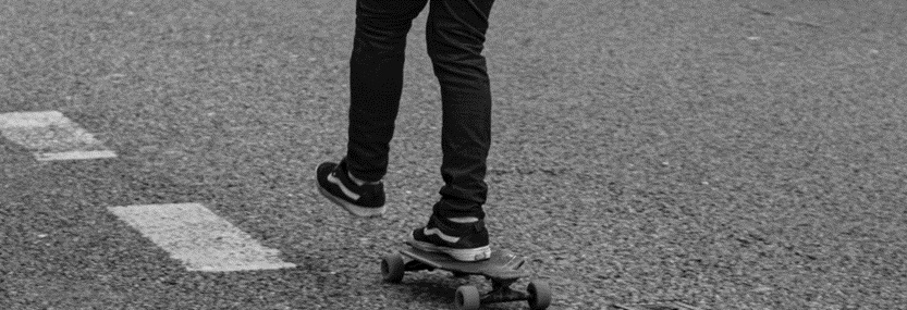 Back view of a young man skateboarding, symbolizing the dynamic journey towards goals with the protection of Term Life Insurance.