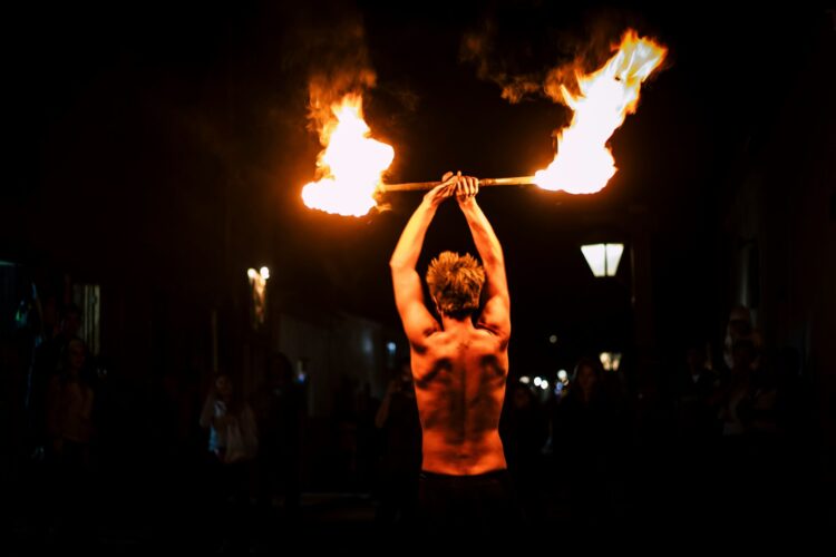 man harnessing fire, by putting on a fire show- to illustrate Harnessing Tax-Free Growth in Indexed Universal Life Insurance